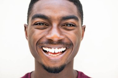 Close up portrait happy young african American man laughing against white background 