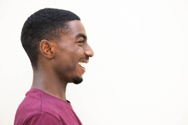 Close up profile portrait laughing young african american man against isolated white background 
