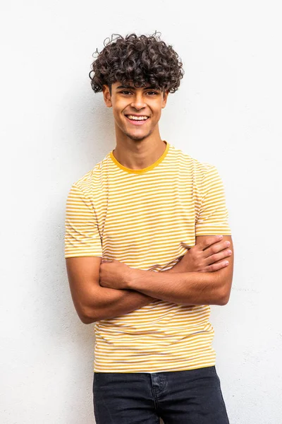 Portrait cool young north African man smiling with arms crossed 