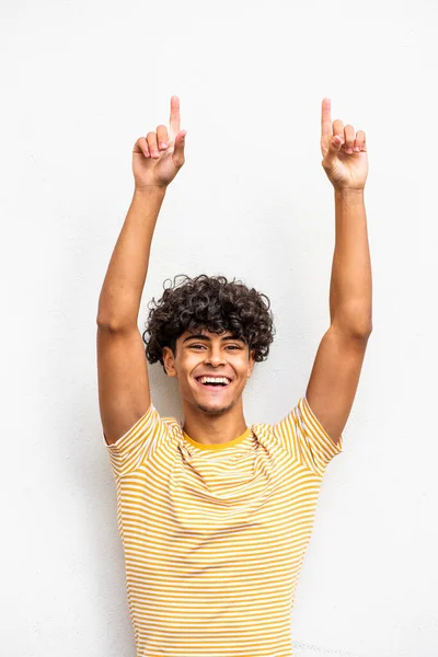 Portrait happy young man with arms raised and fingers pointing up