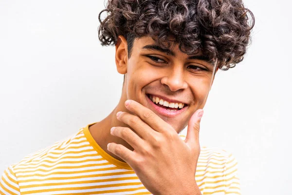 Close up portrait smiling young North African man with hand on chin and glancing away