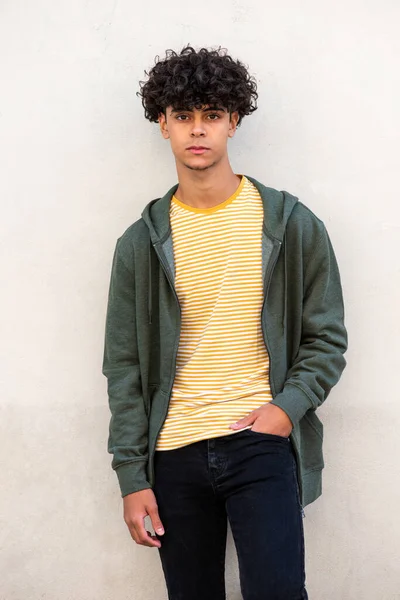 Portrait cool young male model posing by white wall