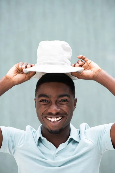 Close Portrait Happy Young African Man Laughing Holding Hat Head — Φωτογραφία Αρχείου