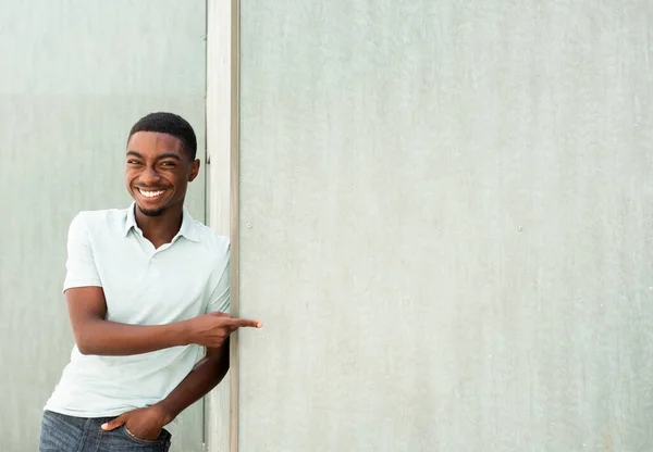 Portrait Happy Young African Man Leaning Wall Pointing Finger Empty — Photo