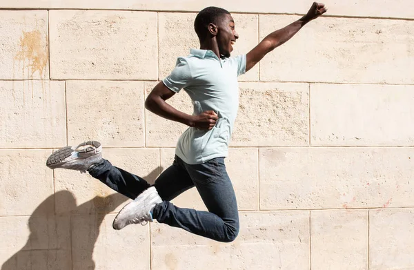 Profile Portrait Happy Young Black Man Jumping Arms Outstretched Wall — стоковое фото