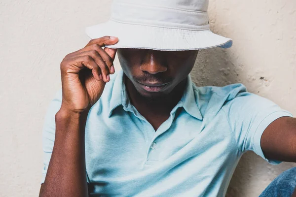 Close Portrait Young Black Man Sitting Wall Hat Covering Face — Stockfoto