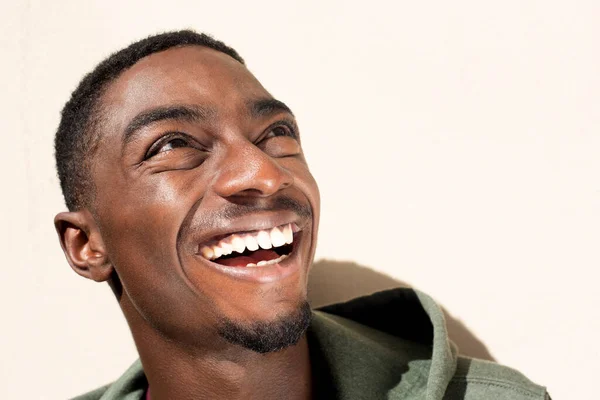 아프리카 미국인 남자가 웃으며 배경으로 올려다보는 사진을 클로즈업하고 — 스톡 사진