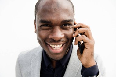 Cep telefonuyla konuşan gülümseyen siyahi iş adamının portresini kapat.
