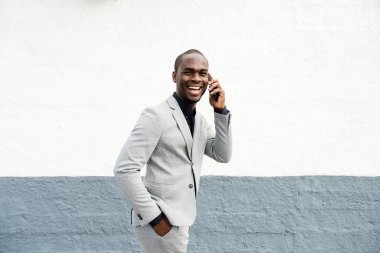 Afro-Amerikan iş adamının duvardan duvara telefonla konuşurken çekilmiş bir portresi.