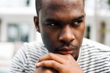 Afro-Amerikan portresini yakından çek. Düşünüyor ve bakıyor, çene çeneye.