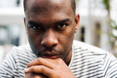 Kapalı portre Afro-Amerikan adam dik dik bakıyor.