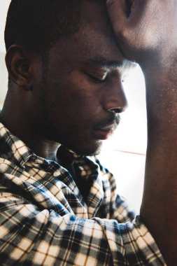 Yan portreyi kapat. Afrikalı Amerikalı bir adam. Gözleri kapalı düşünüyor. 