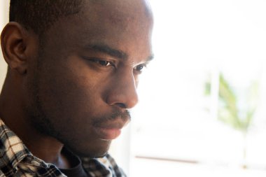 Kapalı yüz portresi. Bir siyah adam dik dik bakıyor.