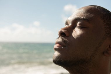 Kapalı deniz manzaralı Afro-Amerikan portresi.