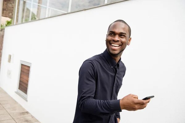 Portrét Afroameričana Usmívajícího Mobilním Telefonem Ruce Při Chůzi Ven — Stock fotografie
