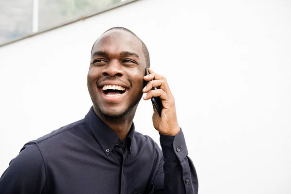 Крупный План Портрета Улыбающегося Афроамериканца Разговаривающего Сотовым Телефоном Белой Стеной — стоковое фото