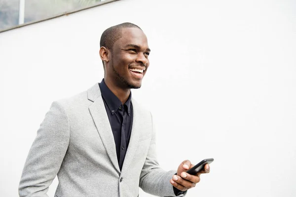 Portrét Pohledného Afroamerického Obchodníka Usmívajícího Mobilním Telefonem Bílé Stěny — Stock fotografie