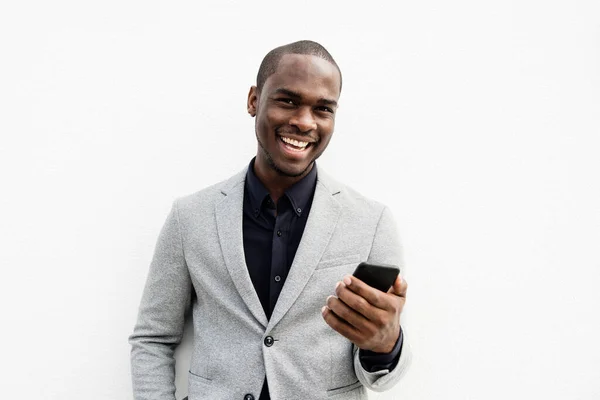 幸せなアフリカ系アメリカ人ビジネス男笑いとともに携帯電話によって白い背景 — ストック写真