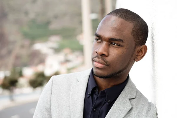 非洲年轻英俊男子靠在墙外的近照 — 图库照片