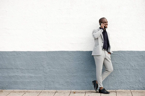 Полный Портрет Улыбающегося Африканского Бизнесмена Стоящего Стены Разговаривающего Телефону — стоковое фото