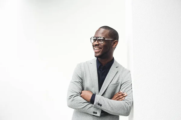 Portrét Usmívajícího Afrického Amerického Podnikatele Opírajícího Zeď Brýlemi Zkříženýma Rukama — Stock fotografie