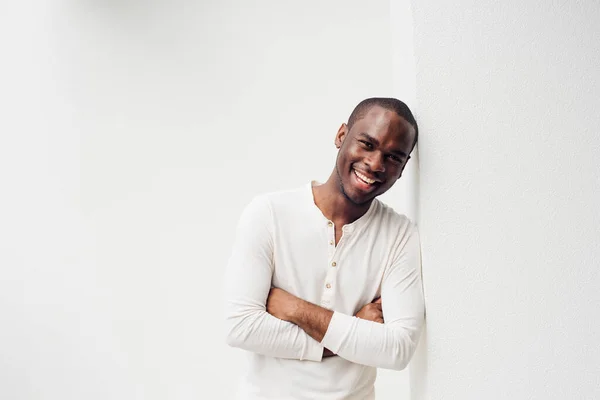 ハンサムな笑顔のアフリカ系アメリカ人の男の肖像画腕を組んで壁にもたれて交差 — ストック写真