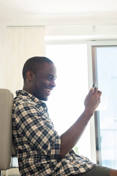 Retrato Lateral Hombre Afroamericano Feliz Sentado Suelo Con Teléfono Móvil — Foto de Stock