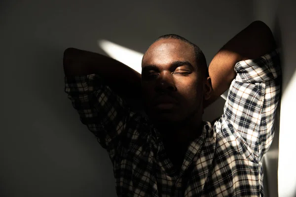 Afro Amerikan Portresi Elleri Başının Arkasında Gözleri Karanlıkta Kapalı Oturan — Stok fotoğraf