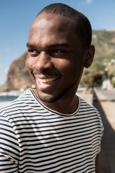 Çizgili Tişörtlü Afro Amerikan Adam Gülümsüyor Başka Tarafa Bakıyor — Stok fotoğraf