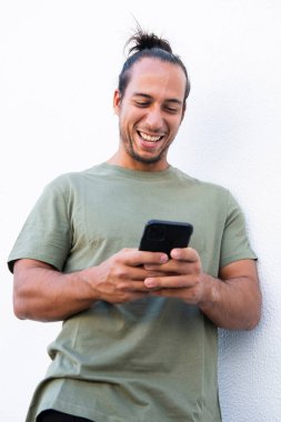 Saçlı mutlu adam beyaz arka plan üzerinde cep telefonu kullanarak kısa mesaj atıyor.