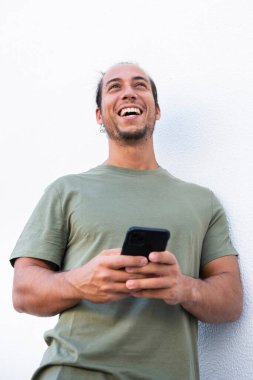 Neşeli adam beyaz arka planda cep telefonu kullanıyor.