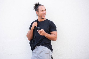 Neşeli adam gözlerini kaçırıyor ve şehir dışında cep telefonu kullanıyor.