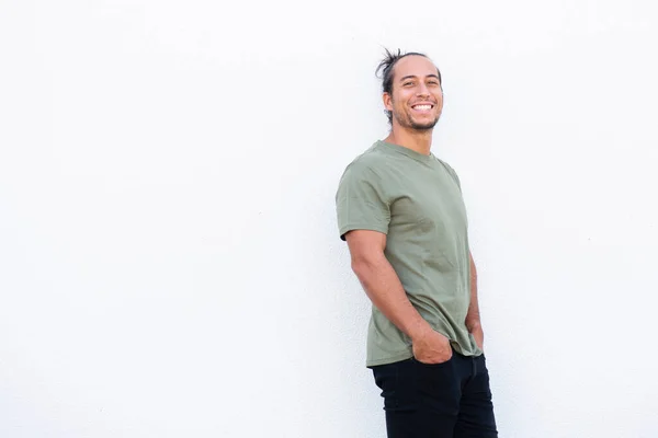 Handsome man with pulled up hair bun and hands in pocket over white background