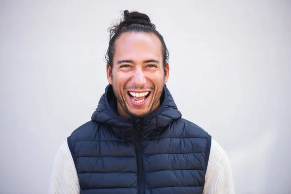 Cheerful man in puffer jacket laughing over white background