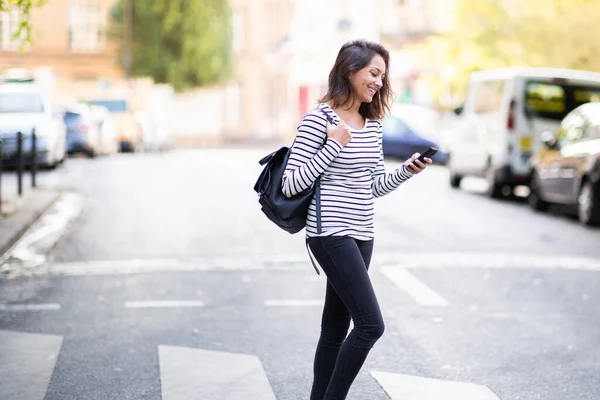 Zijportret Van Jonge Vrouw Oversteken Straat Met Mobiele Telefoon — Stockfoto
