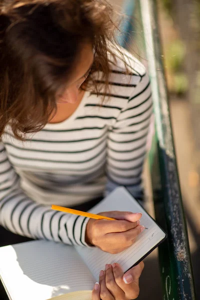 日記にメモを書く若い女性のトップダウンの肖像画 — ストック写真