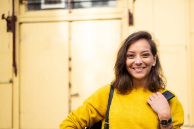 Dışarıda gülümseyen genç bir kadının yatay portresini kapat.