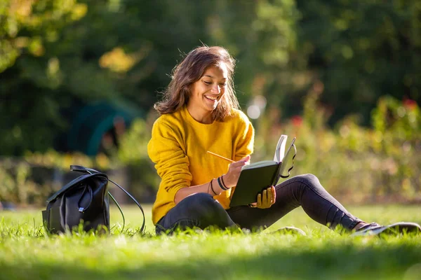 Портрет Счастливой Молодой Женщины Сидящей Траве Парке Пишущей Книге — стоковое фото