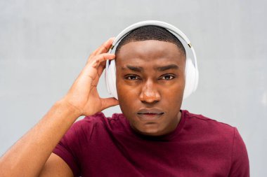 Kulaklıkla müzik dinleyen ve dik dik bakan ciddi bir Afrikalı Amerikalı adamın portresini yakından çek.