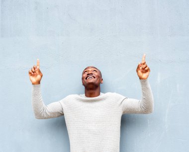 Mutlu Afro-Amerikalı bir adamın portresi yukarı bakıyor ve parmakla işaret ediyor