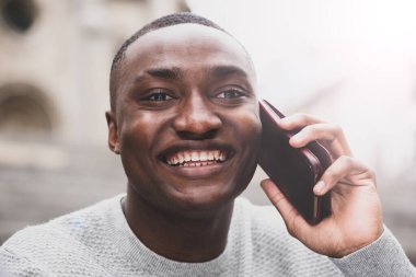 Cep telefonuyla konuşan mutlu bir Afrikalı Amerikalının portresini kapat.