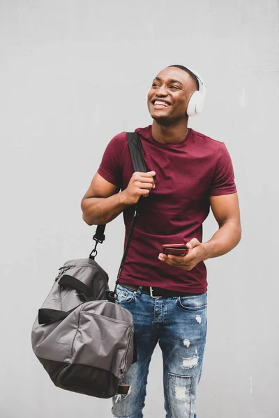 Porträtt Glad Afroamerikansk Man Med Väska Och Mobiltelefon Lyssnar Musik — Stockfoto