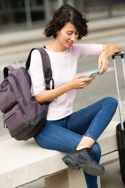 Happy Kobieta Podróżnik Wiadomości Pomocą Telefonu Komórkowego Podczas Siedzenia Zewnątrz — Zdjęcie stockowe