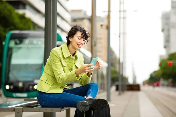 Mujer Feliz Usando Teléfono Móvil Mientras Espera Parada Autobús Ciudad —  Fotos de Stock