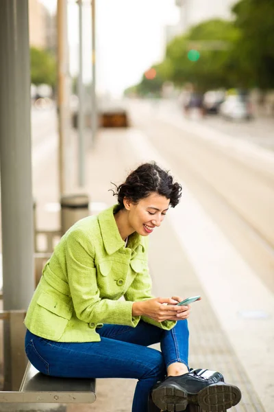Snygg Ung Kvinna Messaging Med Mobiltelefon Medan Väntar Vid Busshållplatsen — Stockfoto