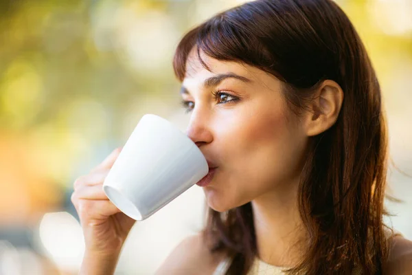 屋外カフェでコーヒーを飲む美しい若い女性の肖像画を閉じます — ストック写真