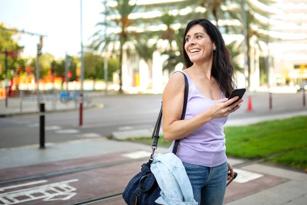 Alegre Mujer Caucásica Con Equipaje Teléfono Inteligente Mirando Aire Libre —  Fotos de Stock