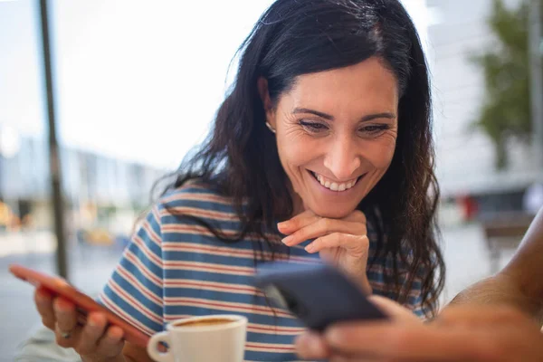 Mujer Feliz Con Amigo Mirando Teléfono Móvil Mientras Está Sentado —  Fotos de Stock