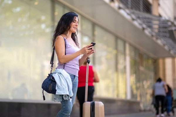 Feliz Viajero Femenino Con Equipaje Usando Teléfono Móvil Aire Libre — Foto de Stock