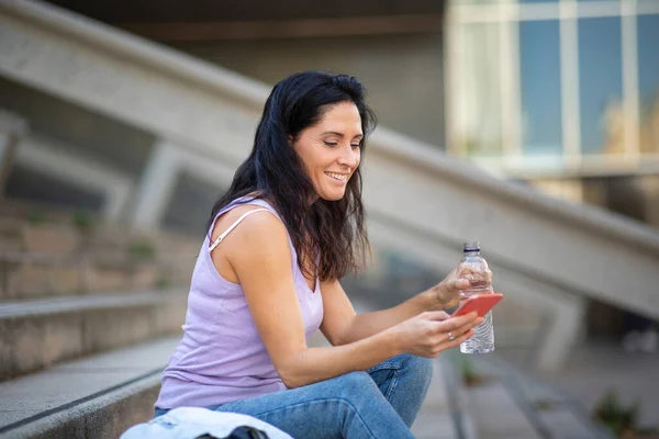 Mujer Caucásica Sonriente Sentada Escalera Usando Teléfono Móvil Mientras Bebe —  Fotos de Stock